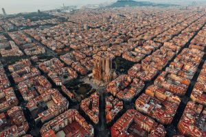 Vista panorámica de Barcelona, con la Sagrada Familia, el paseo marítimo y Montjuïc, destacando la combinación de arquitectura modernista y el mar Mediterráneo